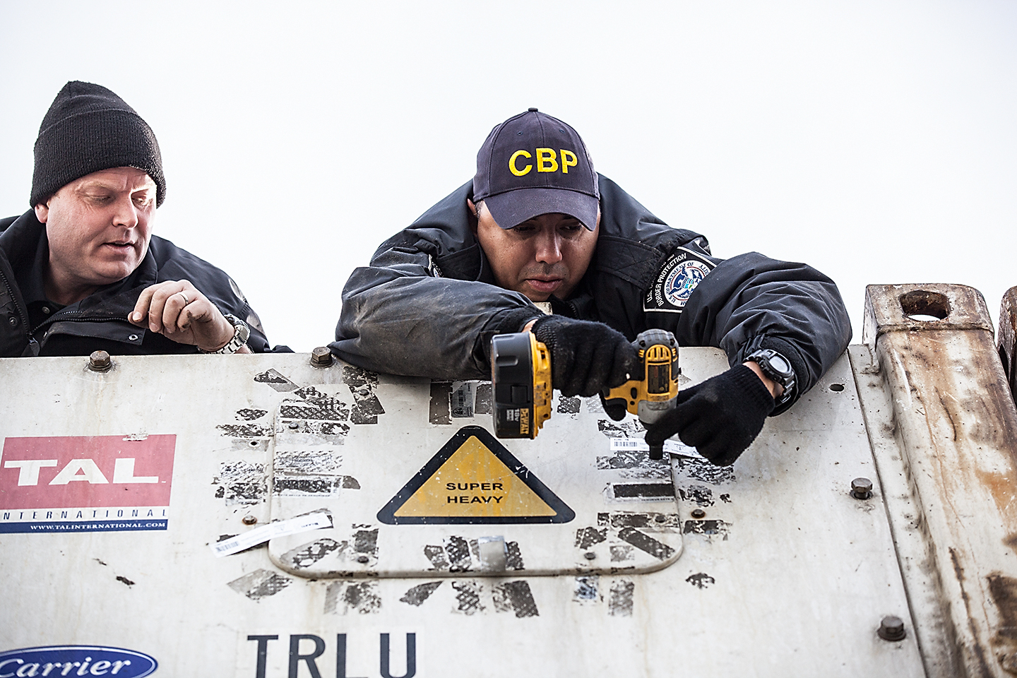 Customs officers checking a container seal at a port